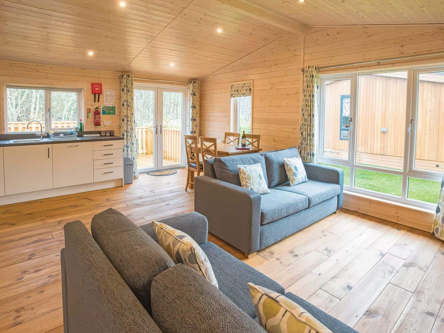 Open plan living area with modern kitchen and floor-to-ceiling windows at Dovestone