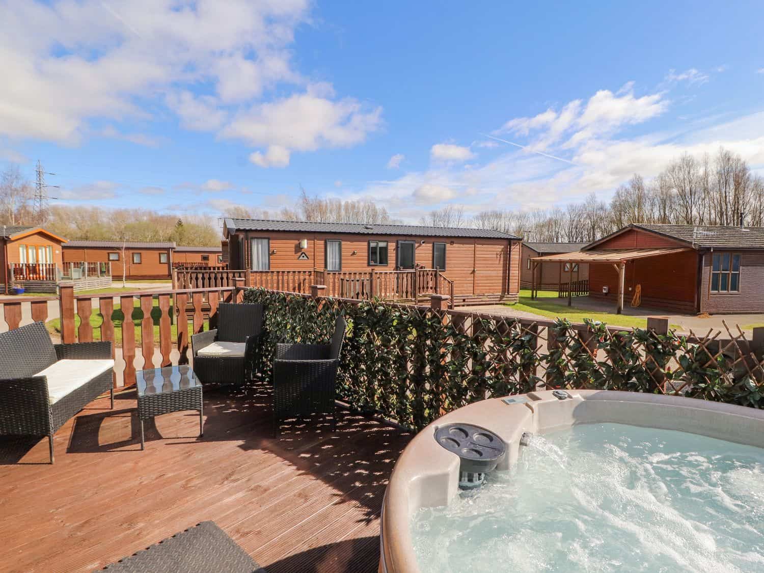 Relaxing hot tub on the wooden deck at Duckling Lodge