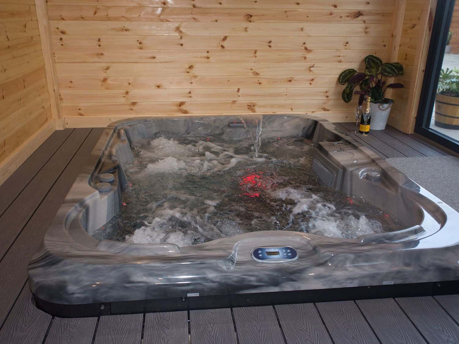 Private enclosed hot tub with bubbling water jets at Height End Farm Log Cabin