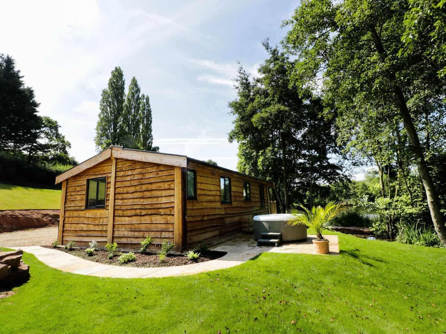 Kingfisher cabin with private hot tub on stone patio surrounded by nature