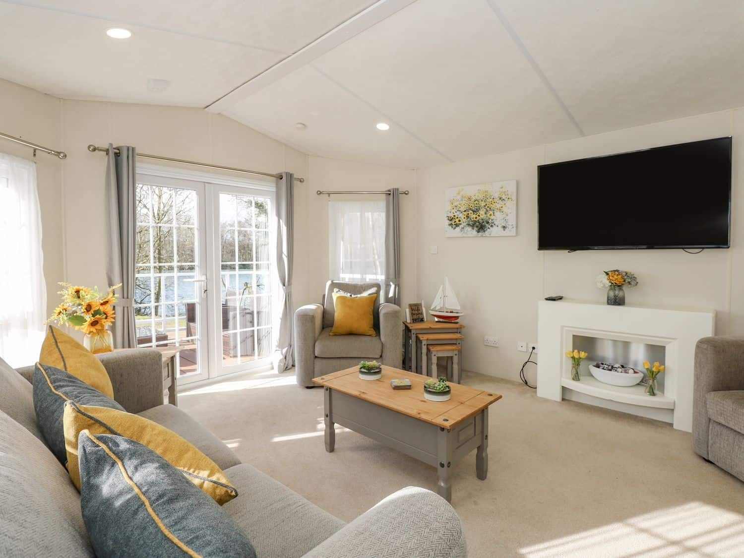 Open plan living area with comfortable sofas and views across the garden