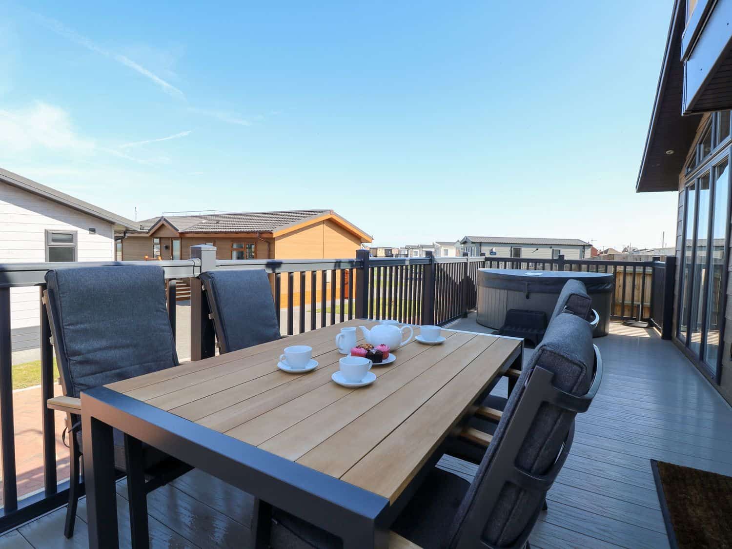 Outdoor deck area with dining furniture and coastal views at Sandy Snug