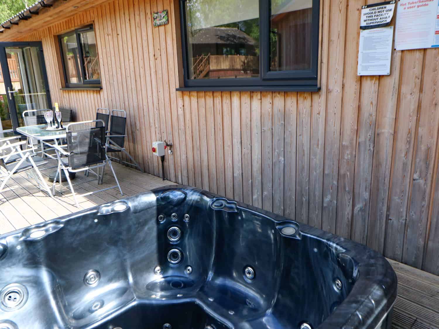 Private hot tub surrounded by woodland at Broken-Sky Lodge