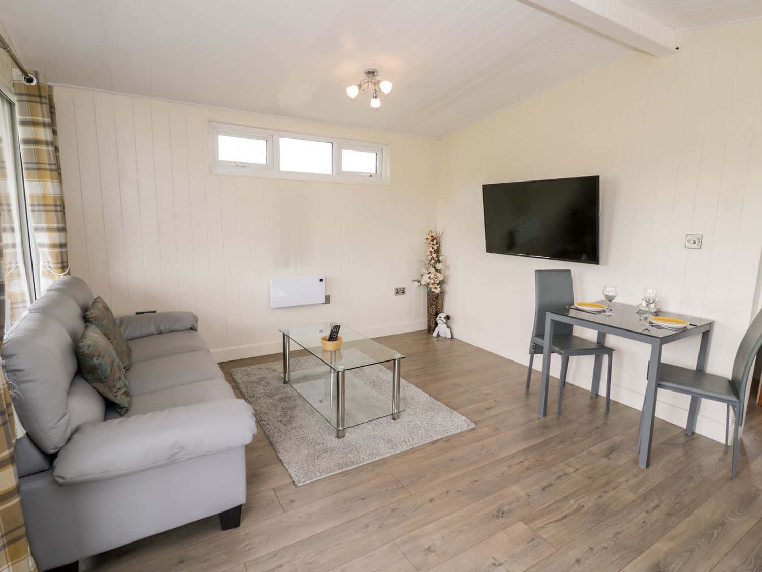 Living room with grey sofa and glass coffee table at Cotswold View 3