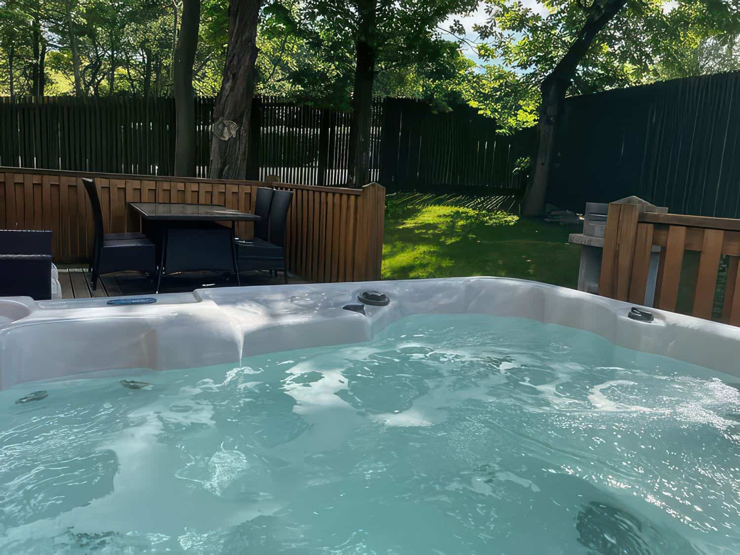 Private hot tub on enclosed veranda with Peak District views at Dovestone Lodge