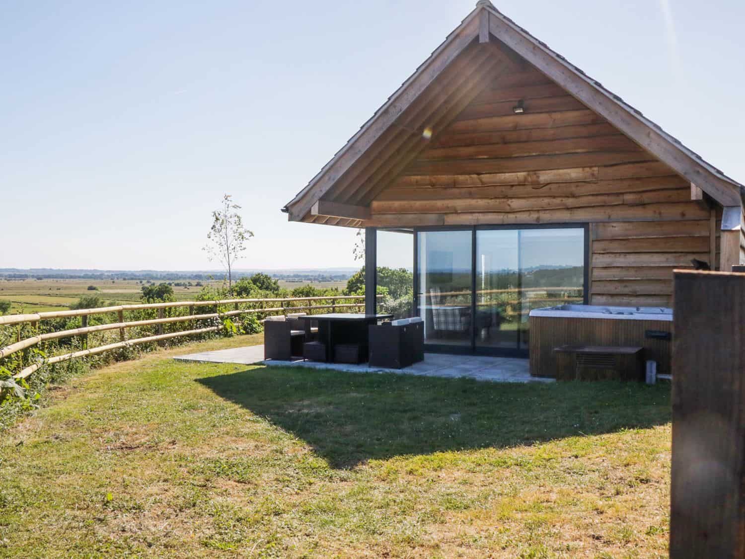 Heron Lodge timber cabin at Castle Farm Wedmore with countryside backdrop