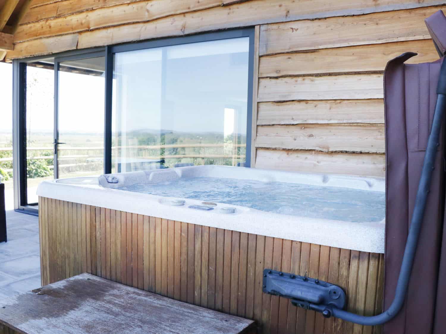 Bubbling hot tub on private deck at Heron Lodge Castle Farm