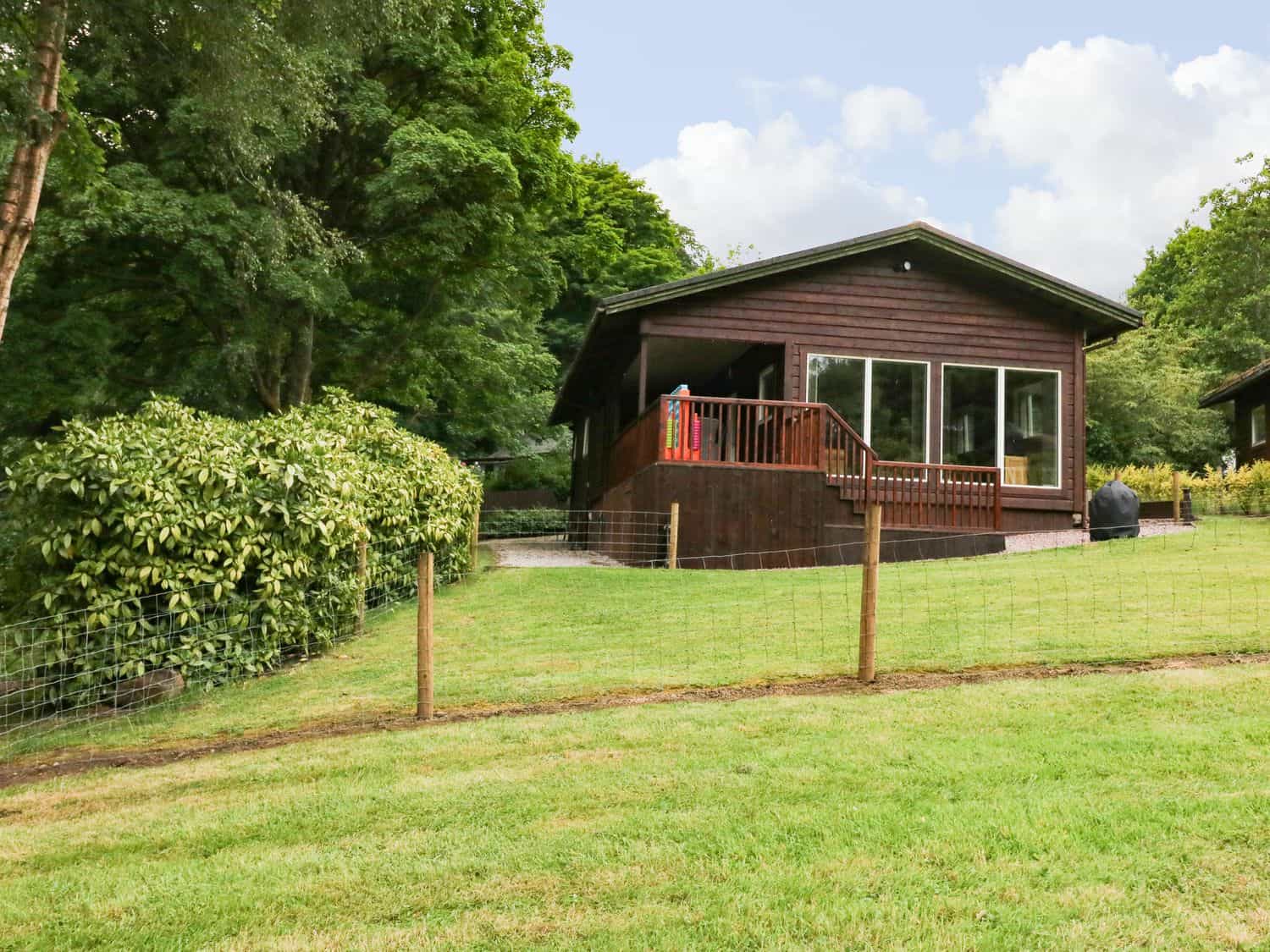 Kipling Lodge timber cabin with landscaped garden overlooking Rudyard Lake