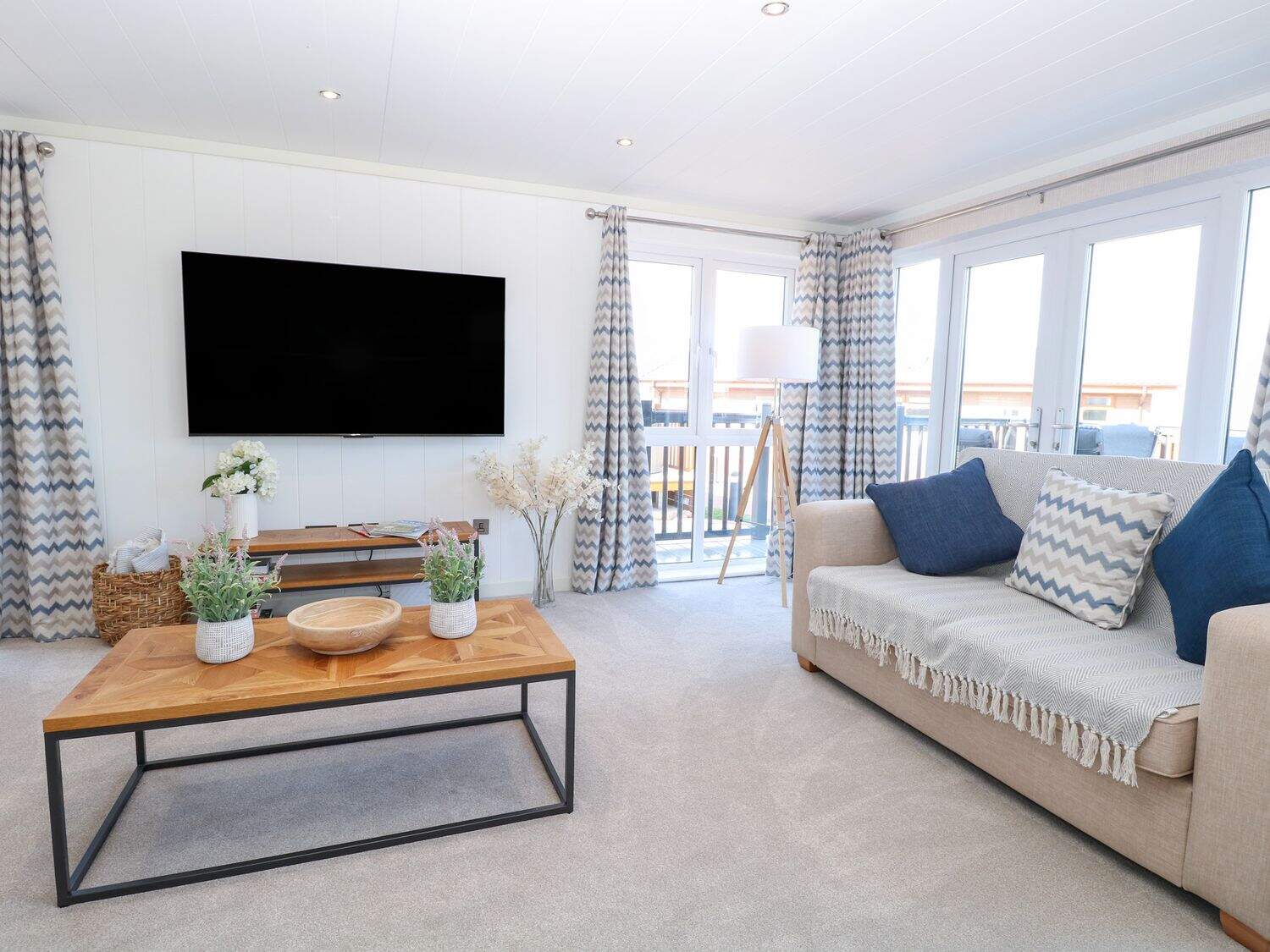 Contemporary living area with TV and comfortable seating at Sandy Snug